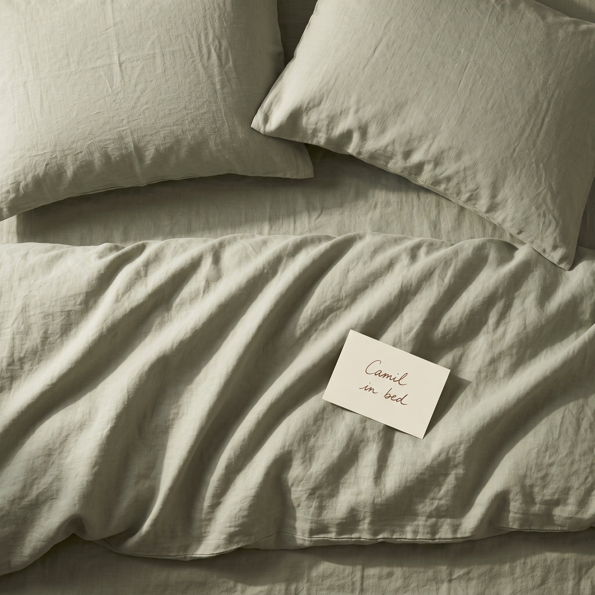 Soft sage green bed linen set seen from above