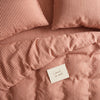 Dusty terracotta striped bed linen set seen from above