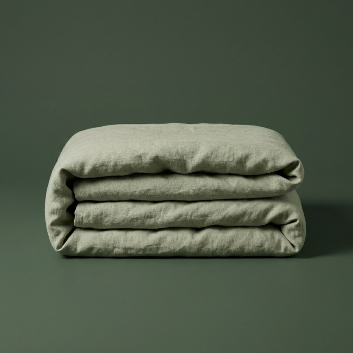 Close view of the corner of the sage green duvet cover folded back over a pillow