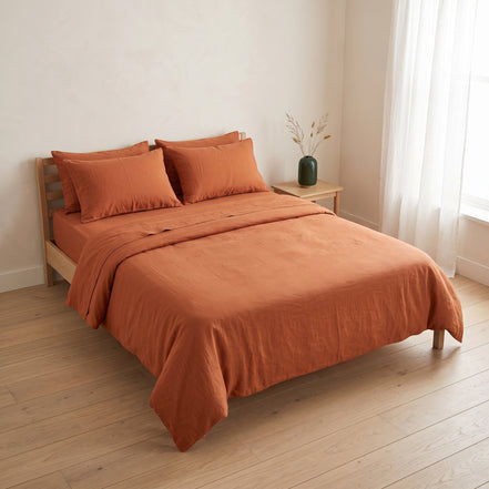 Double bed made up in the full warm rust linen set
