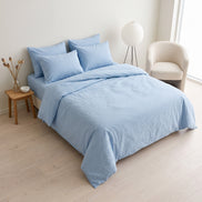 Double bed made up in the full pale blue striped linen set