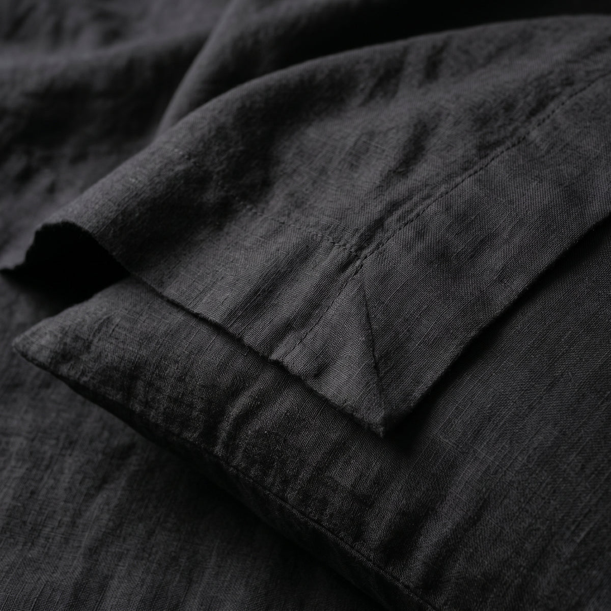 Close view of the black linen, the weave picked out by raking light
