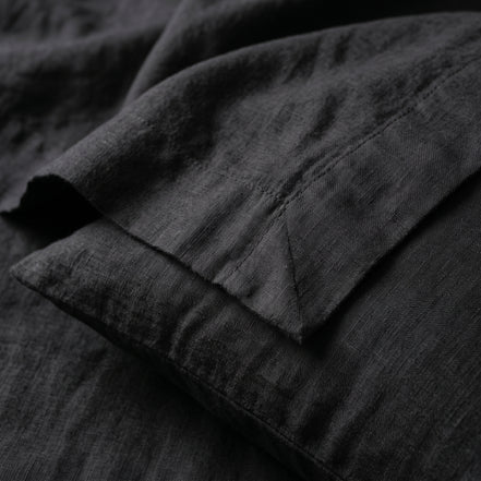 Close view of the black linen, the weave picked out by raking light