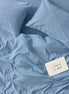 Pale blue striped bed linen set seen from above