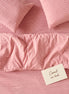 Dusty pink checked bed linen set seen from above