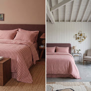 Terracotta striped duvet cover on a low wooden bed beside a curtained window