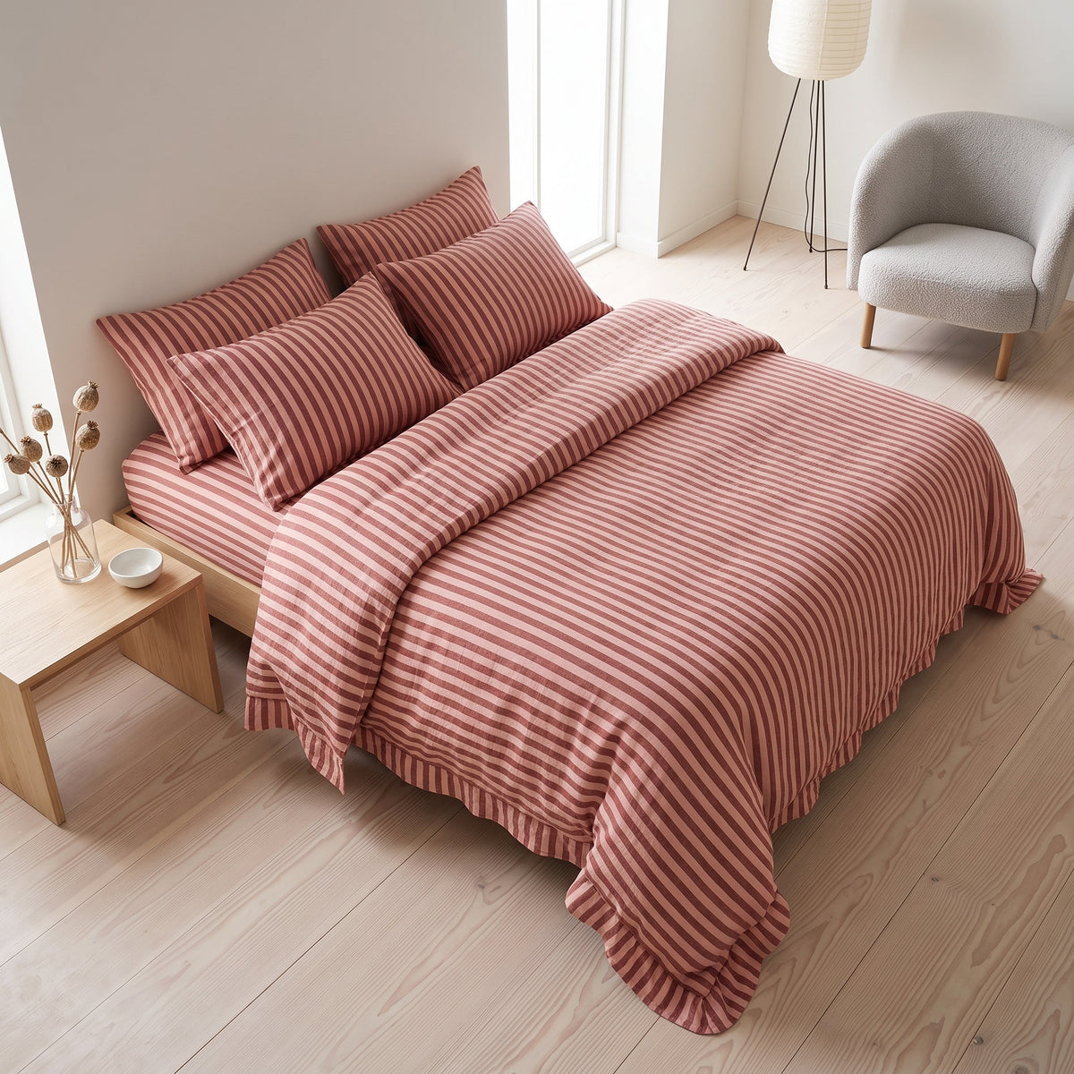 Terracotta striped bedding photographed in a quiet bedroom with pale wood flooring